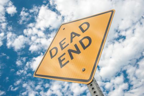 A Dead End sign against a cloudy sky