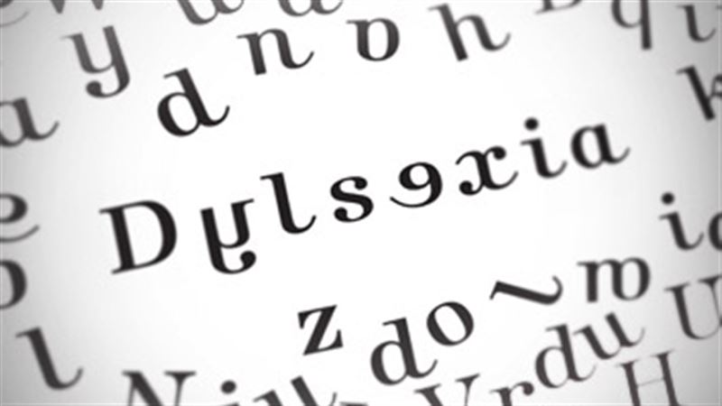 Letters on a page, some letters are arranged to spell "dyslexia", but it is not spelled correctly.