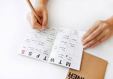 Hands writing in a paper calendar