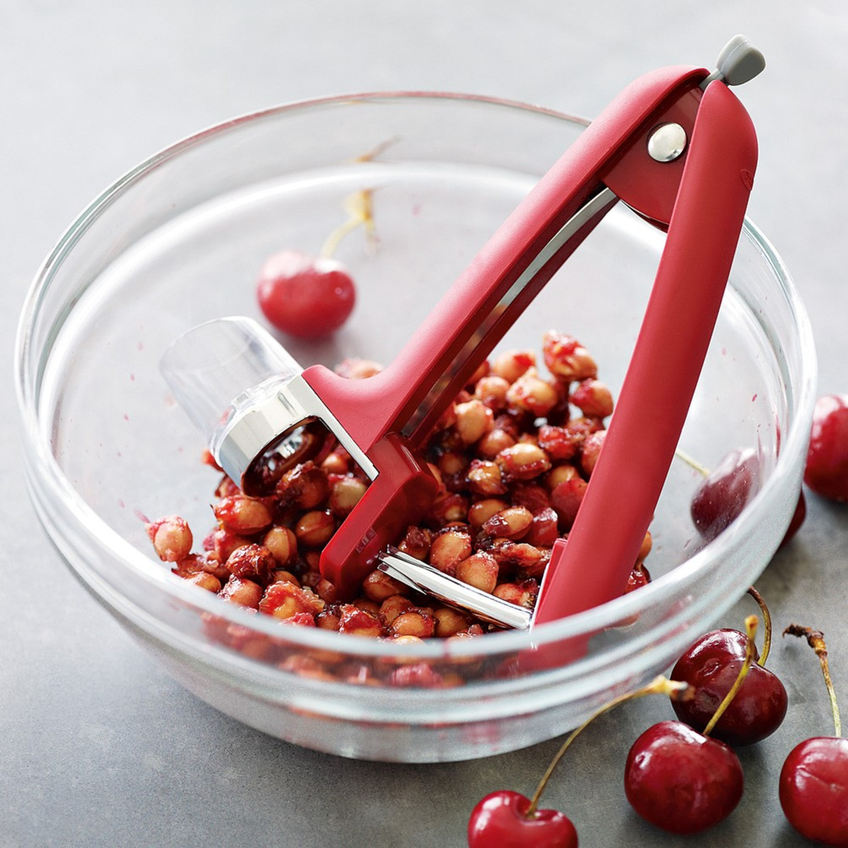 Bowl with cherry pits and OXO cherry pitter.